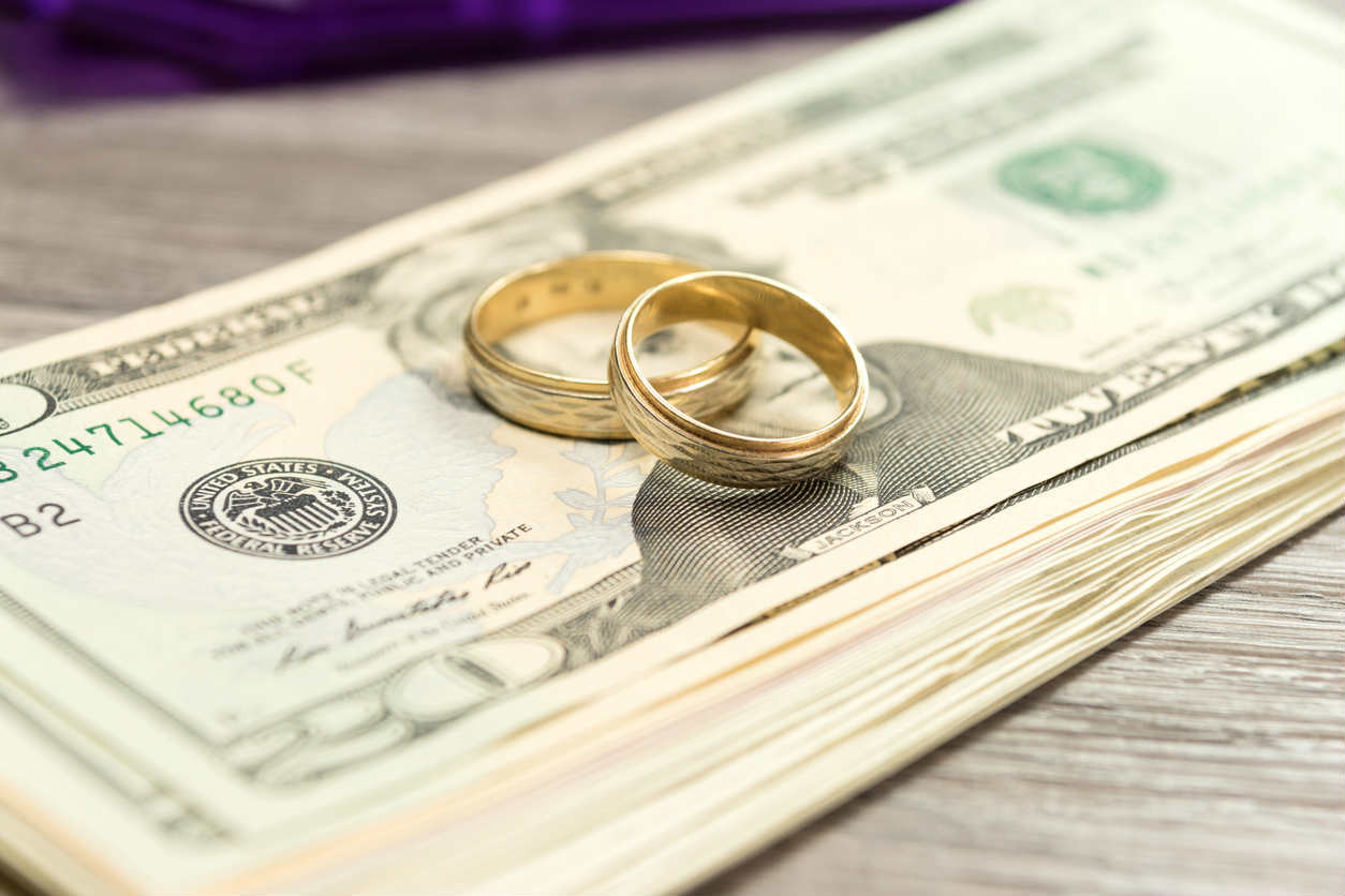 two wedding bands on top of money