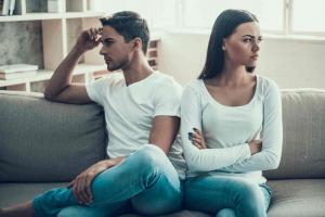 upset couple sitting on a couch